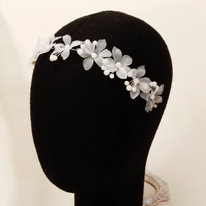 Détail d'un bandeau à fleurs en tulle blanc avec perles pour mariages et coiffures