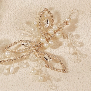 Détail macro d'un bandeau de mariée fait main avec fils dorés, perles et strass marquise