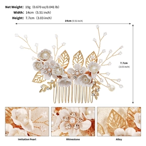 Detail van een bruidshaarkam met gouden bladeren, parels en witte stoffen bloemen