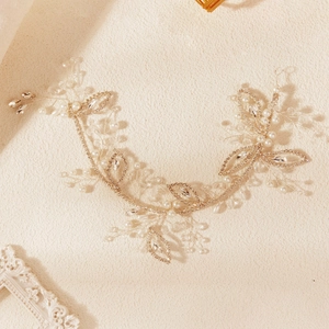 Détail d'une vigne de cheveux de mariée avec perles, cristaux et feuilles dorées à la main
