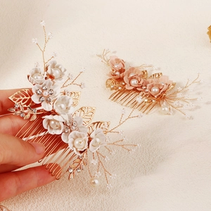 Detail van florale bruidshaarkam met gouden bladeren parels en sprankelende strass