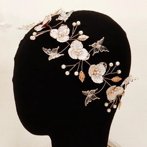 Detail of bridal headband featuring handcrafted white flowers and gold wire butterflies