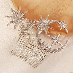 Detailed close-up of a silver star and moon hair comb with sparkling rhinestones and pearls