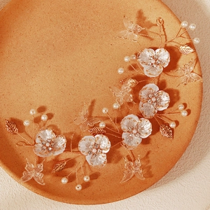 Forest bridal hairband with beads, white flowers and golden butterflies on orange plate