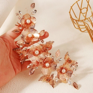 Dettaglio della fascia da sposa dorata con foglie di cristallo e fiori di perle