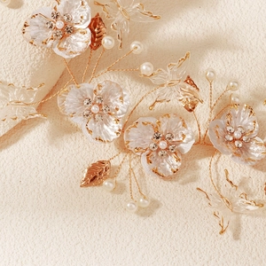 Close-up of handmade bridal headband with pearls, gold leaves and white flowers