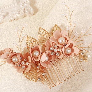 Gouden bruidshaarkam met roze stoffen bloemen, parels en bladaccenten