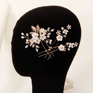 Close-up of bridal flower hair pins with pearls and crystals on a black display