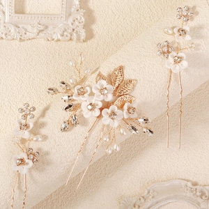 Detailed macro view of handmade bridal hair pins with white petals and pearls