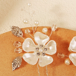 Handmade bridal hair pin featuring white acrylic flowers with pearls and crystals