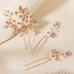 Detail of bridal gold flower hair pins with pearls and resin petals for wedding hairstyles