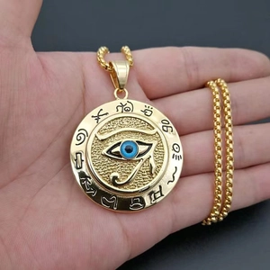 Detailed close-up of Eye of Horus pendant with blue inlay held in hand for scale