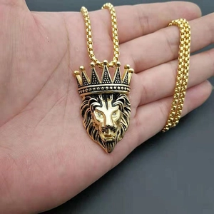 Detailed close-up of a gold-plated lion head pendant with a crown and sparkling zircon eyes