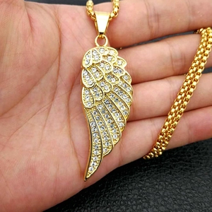 Détail macro du pendentif aile d'ange plaqué or avec cristaux blancs et chaîne