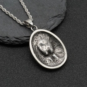 Vintage eagle-inspired oval steel pendant with turquoise inlay on black rock background