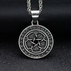 Vue macro du pendentif viking argenté avec pentagramme d'Odin et caractères runiques