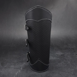 Close-up of black leather bracer with embossed scale texture and silver metal buckles
