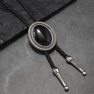 Detailaufnahme von schwarzem Achatstein mit Vintage-Metallbasis am geflochtenen Bolo Tie