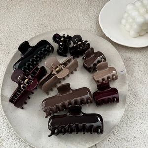 Close-up of assorted earth-tone hair claws in various sizes on a minimalist tray