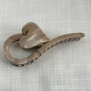 Close-up of large heart-shaped hair claw with brown marble pattern for thick hair