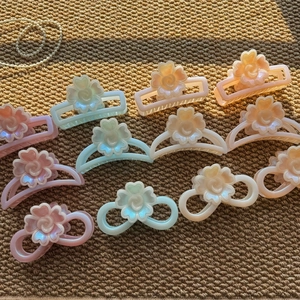 Detail of colorful geometric flower hair claws in macaroon colors on a woven mat