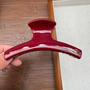 Close-up of a deep red French style hair claw clip with Barrette La France gold lettering