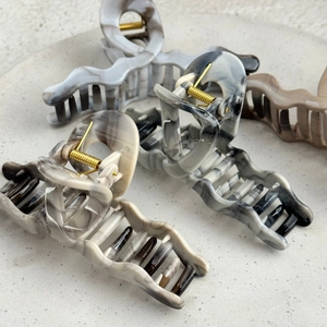 Large wavy marble pattern hair claw clips in various leopard colors on a stone tray