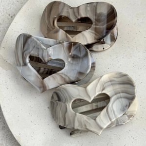 Three heart-shaped hair claws with marble ink texture in grey and brown acetate