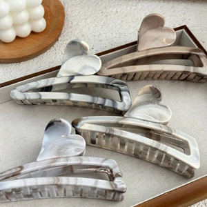 Retro ink marble pattern heart hair claws in four colors on a wooden tray