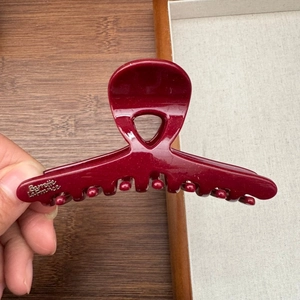 Detail of burgundy resin hair claw with fine shimmer and golden Barrette La France text