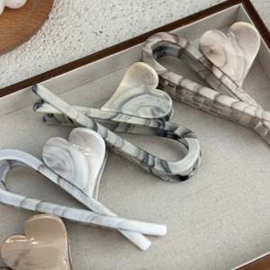 Detail shot of heart-shaped hair claw clips with vintage grey ink marble texture finish