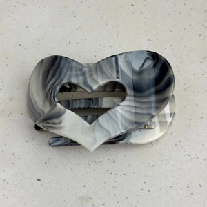 Detailed macro view of heart-shaped hair claw with black and white ink marble texture