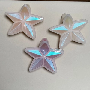 Colorful star-shaped hair claws in pink, white, and purple with iridescent finish