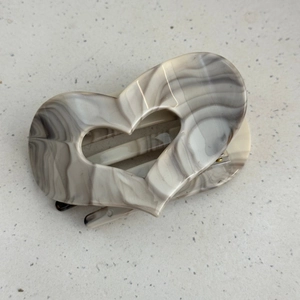 Detail of heart shaped hair claw clip with grey and cream marble ink pattern