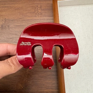 Detailed view of dark red glitter hair claw clip with Barrette LaFrance silver lettering