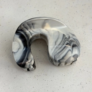 Macro detail of large hair claw clip featuring elegant black and white ink marble patterns