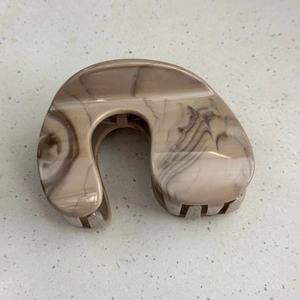 Detailed top view of large marble pattern hair claw clip with brown and cream textures