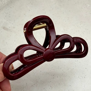 Detail showing Burgundy wine red bow hair claw clip with golden metal spring mechanism