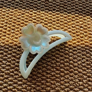 Detail view of the iridescent pearl finish and 3D floral petals on the hair claw clip