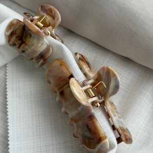 Detailed view of large marble pattern hair claws in cream and brown tortoise shell style