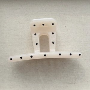 Close-up of cream hair claw clip with black polka dots and durable spring mechanism