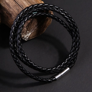 Dettaglio di un bracciale multistrato in pelle intrecciata nera con chiusura magnetica in argento