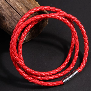 Dettaglio macro del bracciale in pelle intrecciata multistrato rosso con chiusura magnetica