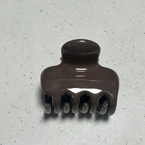 Detail view of glossy brown resin hair claw clip with strong spring and smooth teeth
