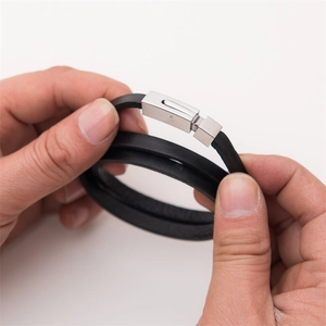 Detail of a double-layered black leather bracelet with a silver stainless steel clasp