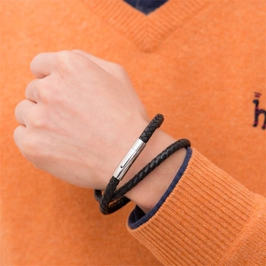 Close-up of double-wrapped black braided leather bracelet with silver magnetic clasp