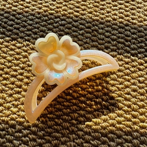 Macro view of floral hair claw clip featuring amber pearlescent resin and cutout design