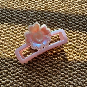 Detail of pink rectangular hair claw clip with 3D pearlescent floral ornament