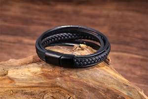 Macro shot of multi-layer black braided leather bracelet with matte metal magnetic clasp
