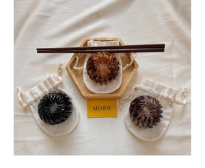 Bird nest retractable hair clips in amber and black colors on an aesthetic tray